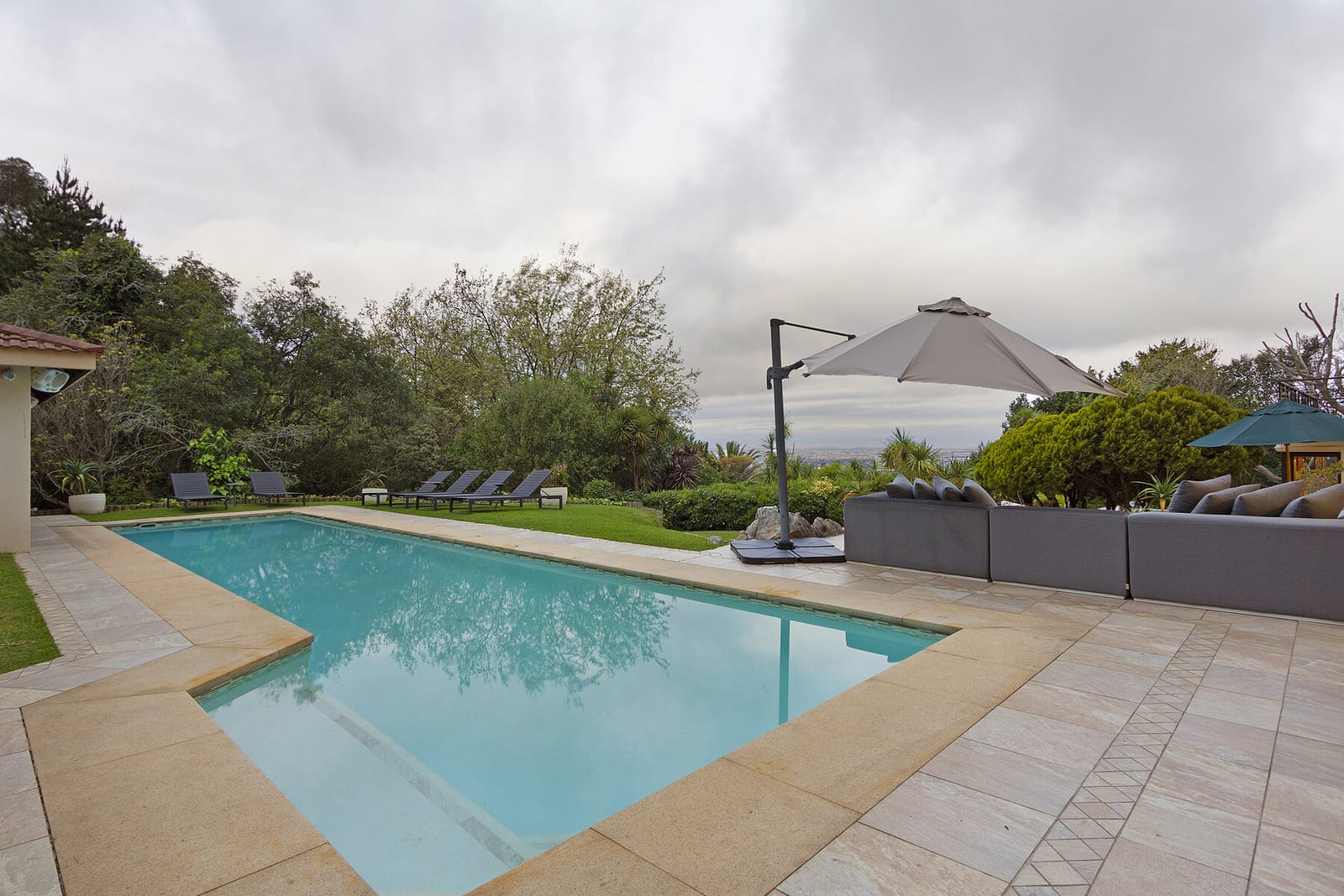 Swimming pool and sun loungers beside the house
